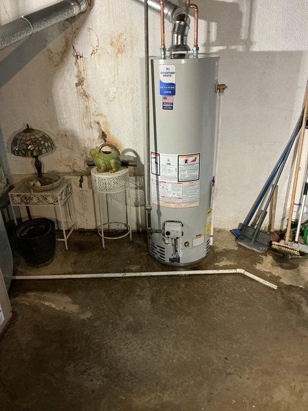 Successfully installed a new 40-gallon water heater in basement utility area with proper venting system and copper pipe connections. Removed old unit and completed all mechanical reconnections of hot water lines according to code requirements. System is now operational with no leaks observed at connection points.
