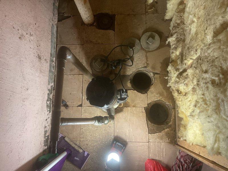 Completed installation of a new sump pit with storm conversion to address non-functioning sump pump. Excavated area for proper drainage system, installed PVC piping with T-junction and clean-out access point, and reconnected the backwater valve to ensure proper water management and basement protection.