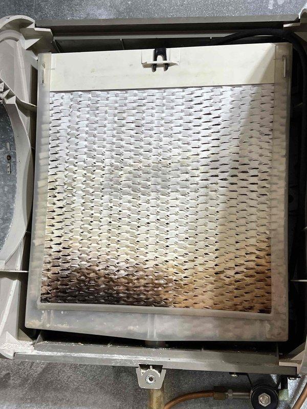 Performed comprehensive tune-up on 21-year-old HVAC system located in basement. Inspected and documented condition of metal mesh filter showing some discoloration and accumulation of debris. Conducted electrical diagnostics using UEi DL389B multimeter, measuring voltage readings of 83.1V and 81.0V. Completed standard inspection of humidifier, thermostat, and hot water tank as part of maintenance service.