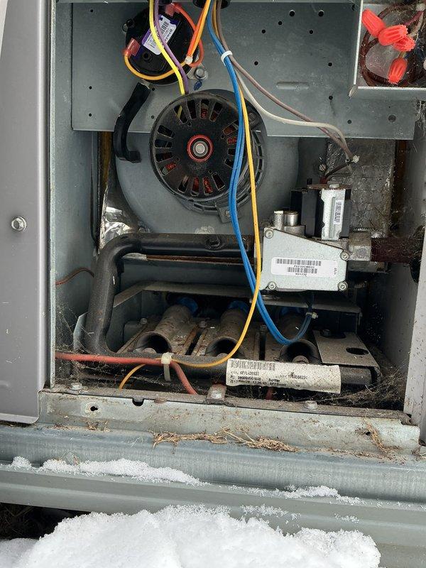 Performed comprehensive tune-up on outdoor HVAC system, including inspection of blower motor assembly, electrical connections, and capacitor. Noted significant rust and corrosion on capacitor terminals requiring monitoring for future replacement. Cleaned accumulated dust and debris from interior components and verified proper operation of humidifier, thermostat, and hot water tank as part of maintenance service.