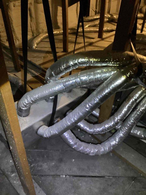 Conducted a free estimate for complete AC system replacement. Current system located in attic with visible flexible ducts featuring foil-faced insulation throughout the space. Basement/utility area inspection revealed multiple bundled metallic ducts requiring attention, alongside existing PVC plumbing infrastructure that will need to be worked around during installation.