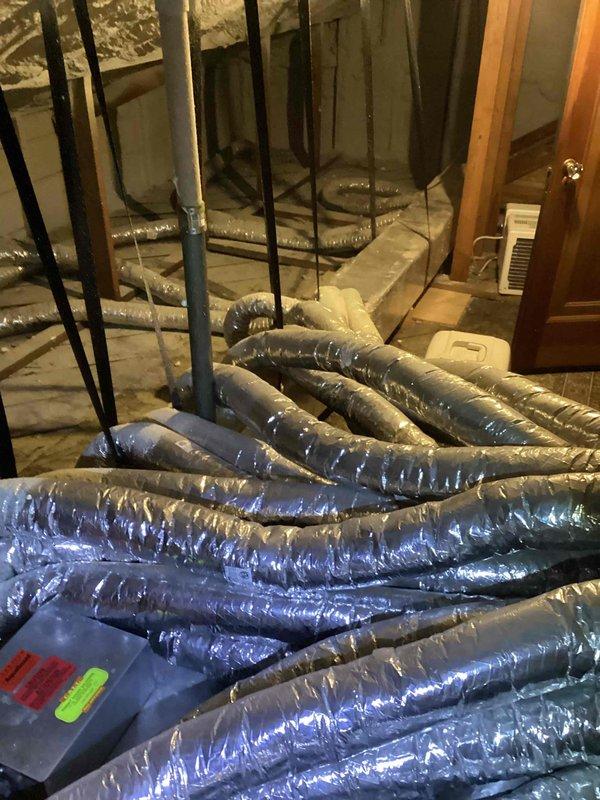 Conducted a free estimate for complete AC system replacement. Current system located in attic with visible flexible ducts featuring foil-faced insulation throughout the space. Basement/utility area inspection revealed multiple bundled metallic ducts requiring attention, alongside existing PVC plumbing infrastructure that will need to be worked around during installation.