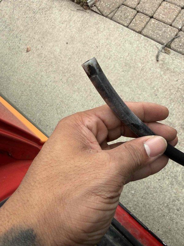 Completed warranty service on residential humidifier system, replacing moldy black drainage tube that connects to sink drain. Removed contaminated rubber tubing and installed new drain line to restore proper drainage function and prevent moisture issues. Documentation includes photos of both the removed deteriorated tube and the new replacement component.