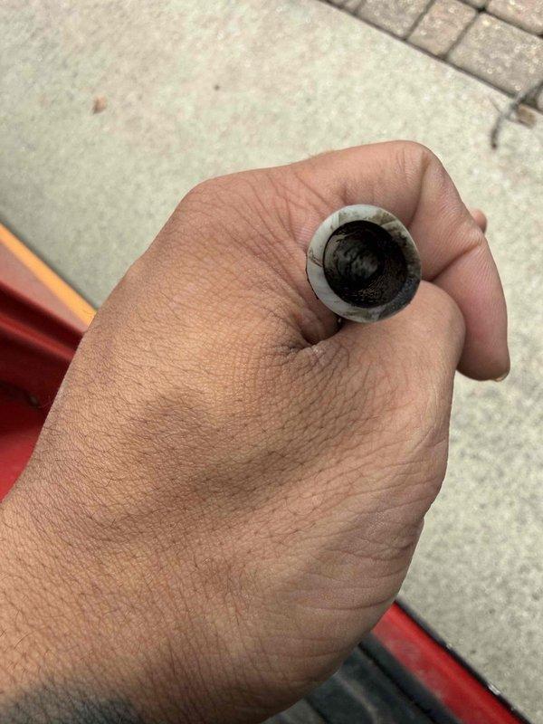 Completed warranty service on residential humidifier system, replacing moldy black drainage tube that connects to sink drain. Removed contaminated rubber tubing and installed new drain line to restore proper drainage function and prevent moisture issues. Documentation includes photos of both the removed deteriorated tube and the new replacement component.