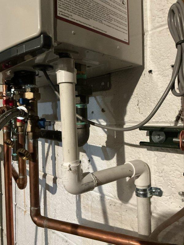 Successfully completed tankless water heater flush maintenance for homeowner. Identified PVC pipe leaking near condensation line which requires warranty service. System inspection revealed proper mounting and connection of supply lines, but interior components showed dust accumulation requiring cleaning.