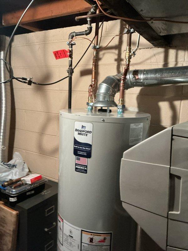 Successfully installed a 40-gallon Bradford White water heater with drip pan and alarm system in utility area. Completed all necessary copper pipe connections, installed proper ventilation ductwork, and ensured all valves and fittings were secure. Final inspection confirmed system operates correctly with no leaks.