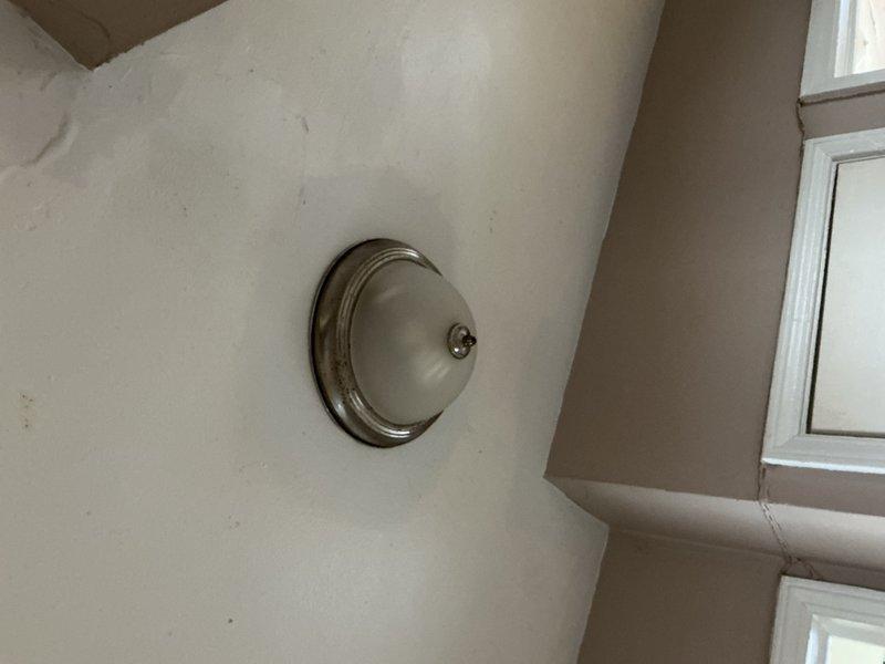 Completed whole home electrical inspection, examining various lighting fixtures and outlets. Verified proper operation of desk lamp with adjustable brass arm and functioning wall outlet. Inspected ceiling-mounted dome light fixture with frosted glass cover and metal trim, confirming secure installation and operational status.