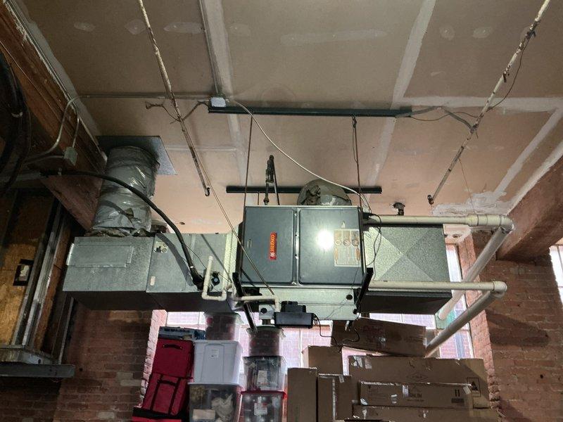 Performed diagnostic assessment on 29-year-old horizontal furnace located in garage, confirming heat exchanger failure as evidenced by tripping rollout switch. Unit is mounted near ceiling with extensive ductwork connections, including insulated round ducts. Prepared comprehensive replacement estimate for both furnace and potential AC replacement, with recommendation to address failing heat exchanger to restore heating functionality.