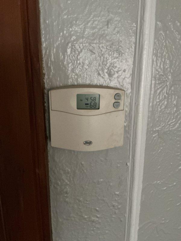 Conducted diagnostic assessment of leaking steam boiler system (likely original to property) located in basement. Boiler is currently operational despite leak. Inspected thermostat functionality and examined existing plumbing configuration including connected ductwork, flue pipe, and valve assemblies. Provided comprehensive replacement estimate for aging unit.