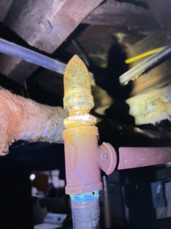 Performed seasonal tune-up on 2-3 year old HVAC system located in basement. Inspected and tested humidifier, thermostat, and hot water tank components. Examined plumbing fixtures and brass valve assembly, noting normal operation with some mineral buildup on valve cap that does not affect functionality.