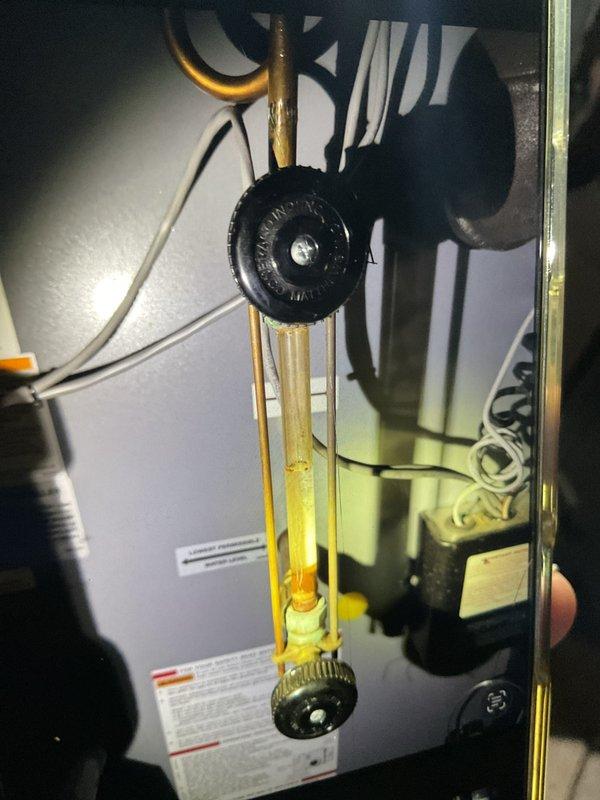 Performed seasonal tune-up on 2-3 year old HVAC system located in basement. Inspected and tested humidifier, thermostat, and hot water tank components. Examined plumbing fixtures and brass valve assembly, noting normal operation with some mineral buildup on valve cap that does not affect functionality.