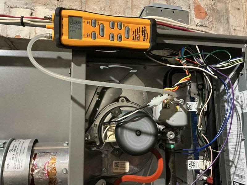 Responded to homeowner complaint of intermittent banging noise from 2023 furnace located in basement. Performed diagnostic testing using Fieldpiece meter which revealed abnormal pressure readings (33.5/32.5) in the system. Inspected blower motor assembly and adjusted fan wheel to eliminate noise issue.
