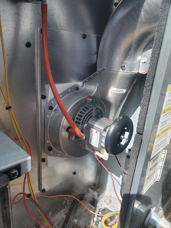 Responded to service call for 2-year-old Goodman packaged furnace that was not turning on properly and producing a humming sound. Upon inspection, discovered faulty inducer motor causing operational issues. Removed access panel, disconnected wiring, replaced inducer motor, and verified proper ignition sequence with visual confirmation of normal flame pattern. Unit now functioning correctly with no unusual noises.