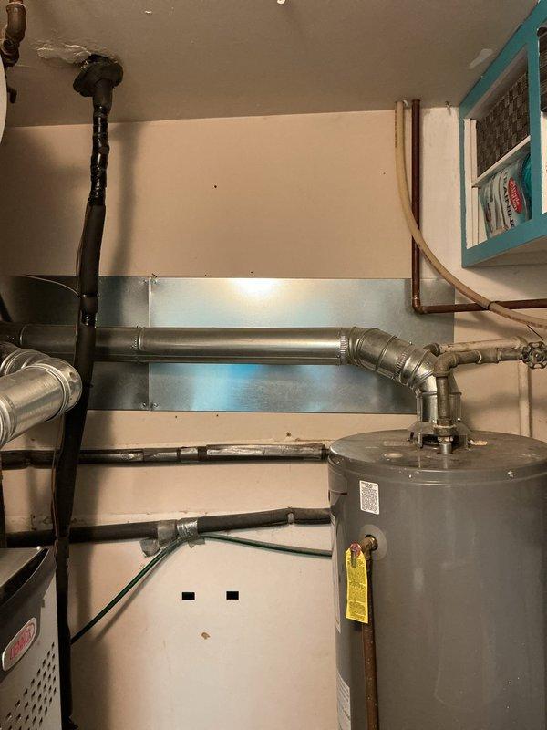 Identified and corrected mechanical violation 503.7.8 by ensuring proper 6" clearance between single wall vent pipe and combustible materials as required by table 503.10.5. Documented compliance with photographic evidence of the water heater installation and surrounding ductwork/piping configuration in the utility area.