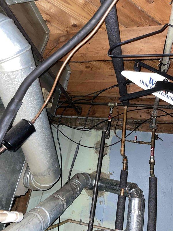 Conducted estimate for furnace replacement of 25-year-old unit located in basement for returning customer. Inspection revealed aging ductwork system with galvanized metal ducting connected to rectangular plenum in structural space. Noted existing plumbing and utility infrastructure including copper supply lines and electrical wiring that will need to be considered during replacement.