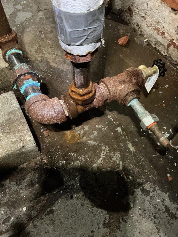 Responded to service call for non-functioning boiler with overfilled sight glass and leaking regulator valve. Diagnosed severe corrosion at copper pipe T-junction causing system failure. Replaced faulty VXT-24 Auto Feeder and repaired corroded piping connection to restore proper boiler operation and water level regulation.