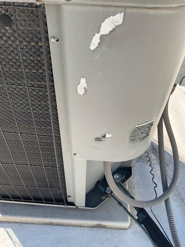 Performed comprehensive Gold AC Inspection on customer's Lennox rooftop unit, documenting multiple areas of exterior panel damage with paint chipping exposing underlying material. System was thoroughly evaluated per maintenance protocol with all findings photographed for documentation purposes.