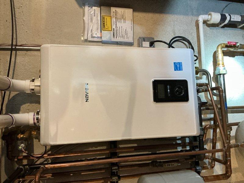 Performed diagnostic assessment on leaking Navien combination tankless water heater system. Conducted maintenance flush to remove mineral buildup and scale. Repaired leak at copper pipe connection point, replaced necessary fittings, and verified proper drainage system functionality with exterior PVC downspouts directing water away from foundation.