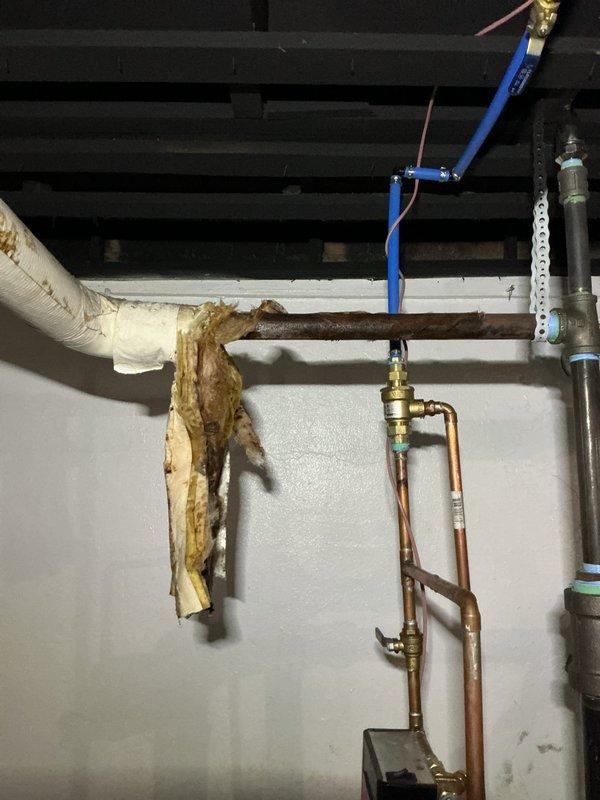 Responded to service call for a 3-month-old boiler exhibiting excessive steam and leakage from pipe onto basement floor. Inspection revealed severe corrosion on copper piping and deteriorated pipe insulation. Replaced damaged section of copper pipe and installed new insulation to resolve the leakage issue and prevent further water damage.