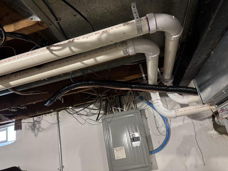 Successfully completed the deferred A/C installation, including proper connection of refrigerant lines, electrical wiring, and installation of the chimney liner. Installed and secured metal ductwork with appropriate elbow joints through the foundation wall, ensuring proper sealing at penetration points. System is now operational with all connections properly insulated and secured.