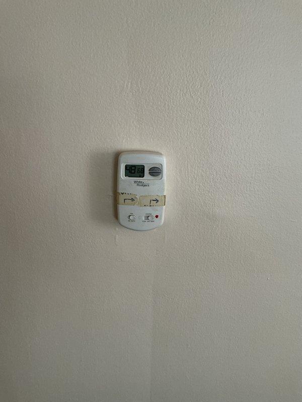 Performed inspection of non-functioning furnace system in customer's home. Observed aged furnace unit with visible rust and discoloration, currently shut off. System includes wall-mounted thermostat reading 56 degrees, rectangular plenum, and round metal ductwork with PVC venting. Provided replacement estimate for natural gas furnace installation.