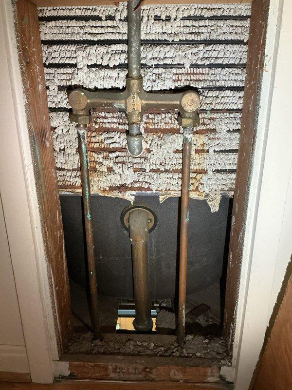 Responded to service call for non-functional shower faucet in main bathroom of 70-year-old home. Created access panel to inspect plumbing, identified corroded brass/copper pipes and T-joint connections causing the malfunction. Replaced deteriorated plumbing components and restored proper water flow to the shower/tub fixture.