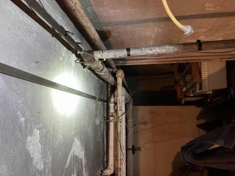 Conducted follow-up site visit to re-evaluate previous estimate. Inspected bathroom fixtures including bathtub/shower enclosure with damaged tile surround and aging water control handles. Also examined basement utility area with deteriorated pipe insulation, visible corrosion on metal components, and signs of moisture damage on concrete wall surfaces. Documented conditions with photographs for revised quote preparation.