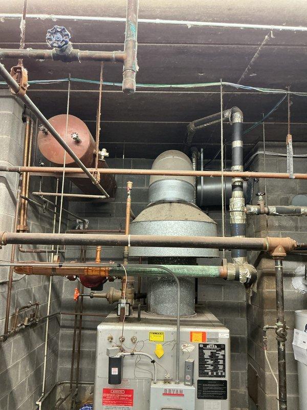Completed estimate for replacement of a 1988 Bryan boiler system that has become cost-prohibitive to repair due to age and parts availability. The existing installation features an extensive network of copper and metal piping with multiple valves, fittings, and auxiliary components including expansion and pressure tanks. Replacement recommended to restore reliable heating functionality.