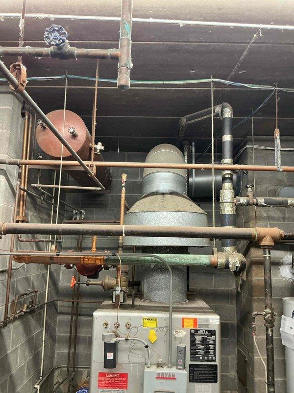 Completed estimate for replacement of a 1988 Bryan boiler system that has become cost-prohibitive to repair due to age and parts availability. The existing installation features an extensive network of copper and metal piping with multiple valves, fittings, and auxiliary components including expansion and pressure tanks. Replacement recommended to restore reliable heating functionality.