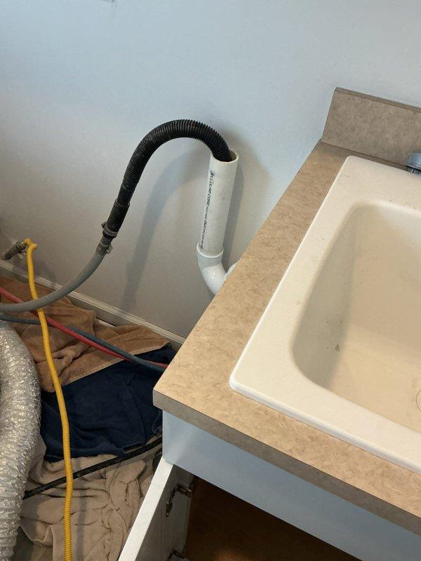 Responded to service call for drainage backup issue where washing machine discharge was causing backup through multiple fixtures extending to kitchen sink. Inspection revealed interconnected drain system with potential blockage in main line. Performed drain clearing service on the affected plumbing system, focusing on the utility sink connection and under-sink P-trap assembly. Successfully restored proper drainage function throughout the system.