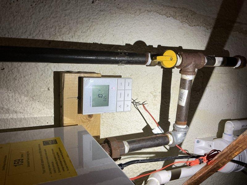 Responded to service call for non-operational tankless water heater related to previous repair. Inspected system components including gas line, temperature control unit (displaying 68°), and electronic control board (showing 208 on display). Diagnosed issue with circuit board connections and repaired faulty wiring to restore proper functionality of the tankless unit.