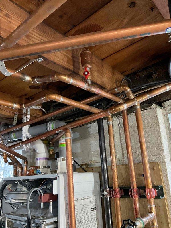 Diagnosed issue with upstairs heating system in a residential property. Inspection of the basement utility room revealed proper functioning of the copper piping system with no visible leaks or damage. Determined the problem was a faulty zone valve preventing proper flow to the upstairs heating zone. Replaced zone valve, bled the system, and confirmed proper heat distribution to all zones.