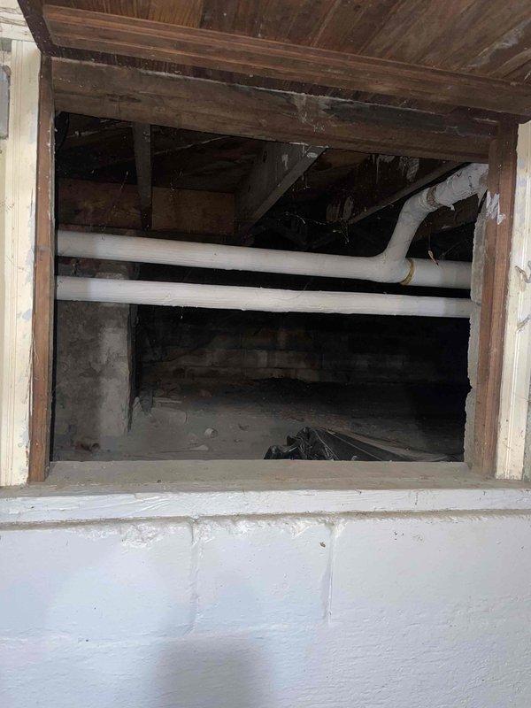Conducted site assessment for mini split installation on first floor of residential property. Inspected crawlspace/basement access area with exposed wooden structural elements and existing PVC plumbing lines. Evaluated utility area containing copper piping, insulated ducts, and electrical wiring for potential integration points. Documented evidence of possible moisture damage that may require remediation before installation proceeds.
