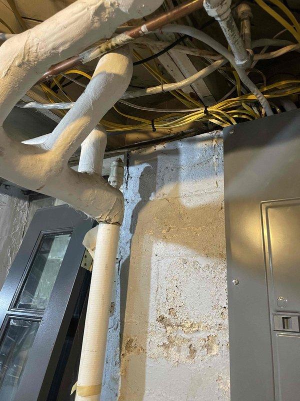 Conducted site assessment for mini split installation on first floor of residential property. Inspected crawlspace/basement access area with exposed wooden structural elements and existing PVC plumbing lines. Evaluated utility area containing copper piping, insulated ducts, and electrical wiring for potential integration points. Documented evidence of possible moisture damage that may require remediation before installation proceeds.