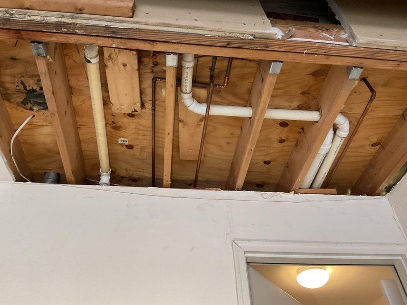 Responded to a water leak in customer's garage. Removed drywall to access the plumbing system, revealing leaking PVC and copper pipes running through wooden wall framing. Repaired damaged pipe sections and connections, ensuring proper sealing and function of the residential water supply system.