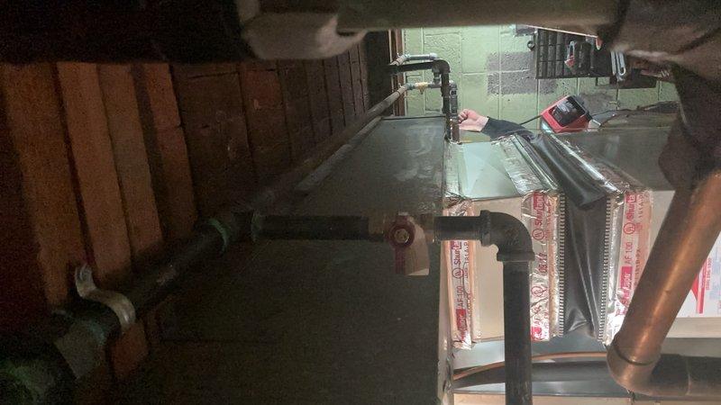 Completed installation of a new water heater in utility area, including proper connection of copper supply lines with hot/cold valves and PVC drainage piping. System was properly vented with appropriate ductwork and all connections were secured and tested for proper operation.