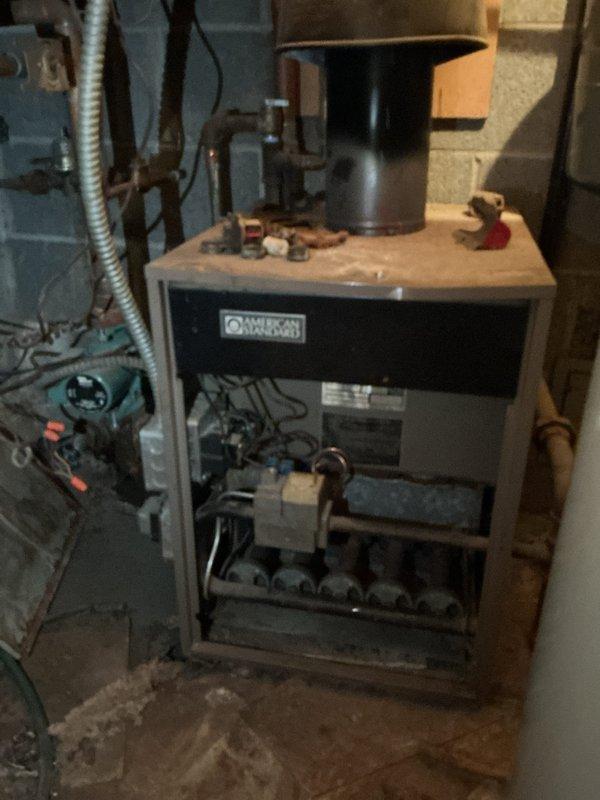 Conducted diagnostic assessment on 50+ year old hot water boiler system producing high carbon monoxide levels. Inspection revealed severely aged American Standard unit with significant safety concerns. Recommended replacement rather than repair due to age of equipment and dangerous CO emissions.