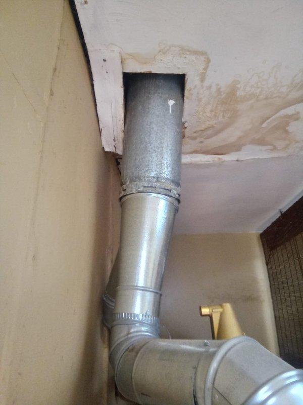 Responded to water leak service call for pipe connected to hot water tank/boiler system. Inspection revealed significant water damage around ceiling duct penetration point, with visible staining and deterioration spreading from the pipe entry. Repaired leak in the metallic ductwork and associated copper pipe connections to prevent further damage to the utility area ceiling.