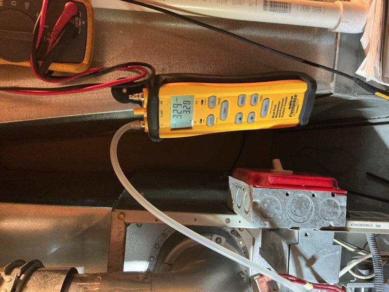 Performed comprehensive tune-up on 18-year-old furnace located in main floor closet. Conducted electrical diagnostics using multimeter, measuring voltage readings (696) across components with specialized probes. Completed temperature differential testing with Fieldpiece meter, recording supply/return temperatures (32°F/12°F) to verify proper system operation.