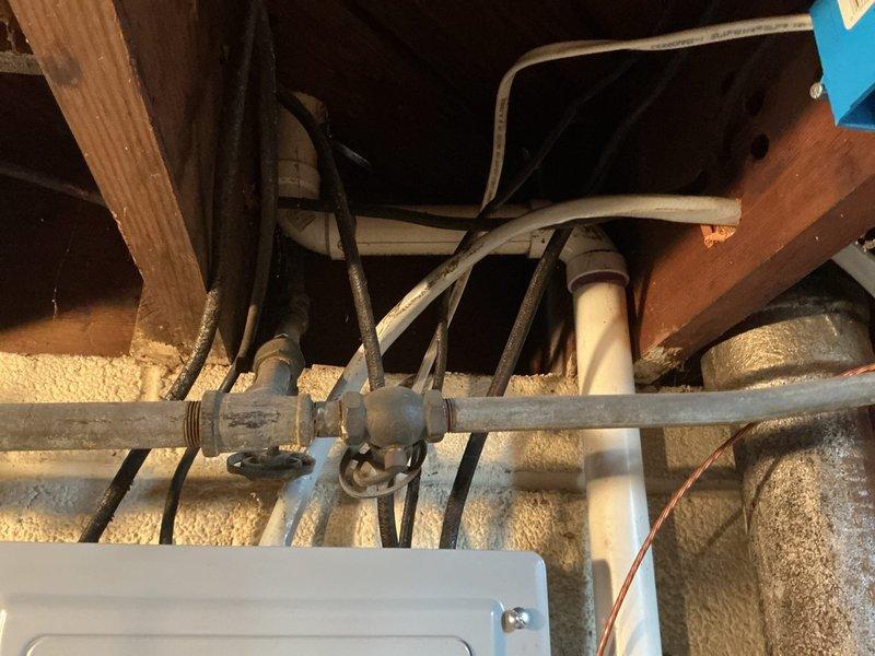 Conducted free estimate for bathroom plumbing replacements including sink faucet, handles, sink drain, and tub drain. Inspection revealed aging metal pipes with threaded fittings beneath the structure and PVC drainage pipes in need of replacement. Documented condition of existing plumbing infrastructure including drain line configuration and electrical panel proximity for comprehensive replacement quote.