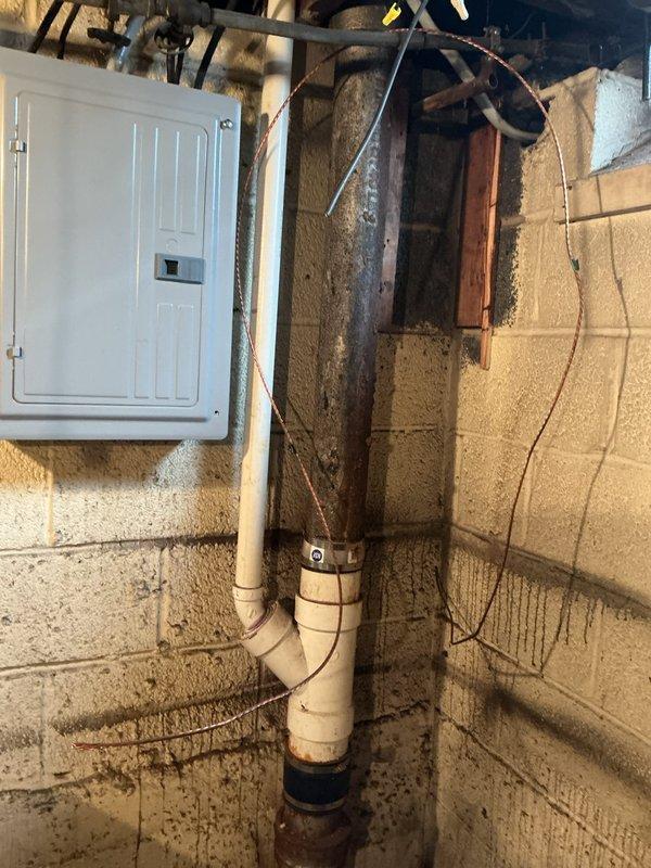 Conducted free estimate for bathroom plumbing replacements including sink faucet, handles, sink drain, and tub drain. Inspection revealed aging metal pipes with threaded fittings beneath the structure and PVC drainage pipes in need of replacement. Documented condition of existing plumbing infrastructure including drain line configuration and electrical panel proximity for comprehensive replacement quote.