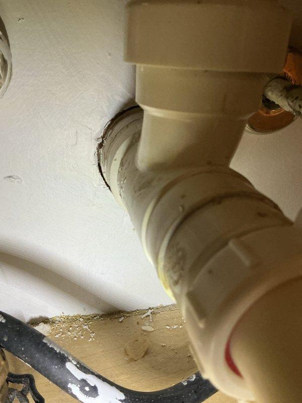 Performed camera inspection of PVC plumbing system, identifying deterioration at wall connection point with visible debris and staining. Documented condition of multiple pipe joints, including PVC with purple primer markings and metal-braided supply lines connected to copper components. Recommended and sold necessary repair services to address the identified issues.