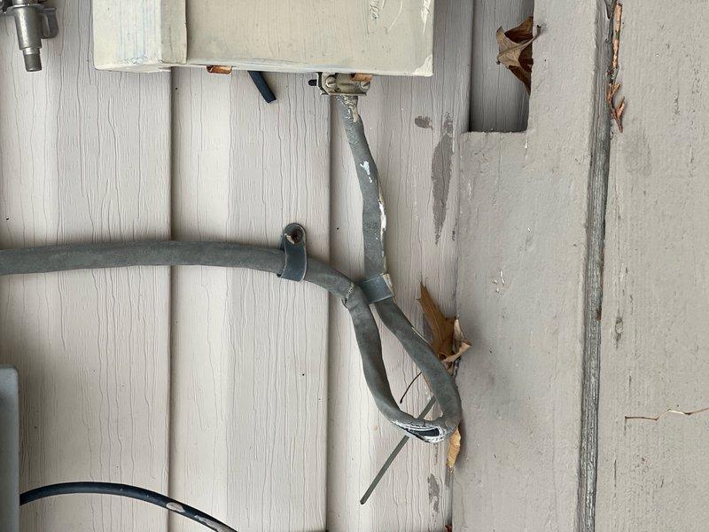 Performed comprehensive inspection of exterior electrical service equipment including meters, conduit systems, and junction boxes. Identified deteriorating wall surface with peeling paint around service entrance panel and Y-branch conduit installation. Documented condition of utility meters and associated wiring connections for future reference.