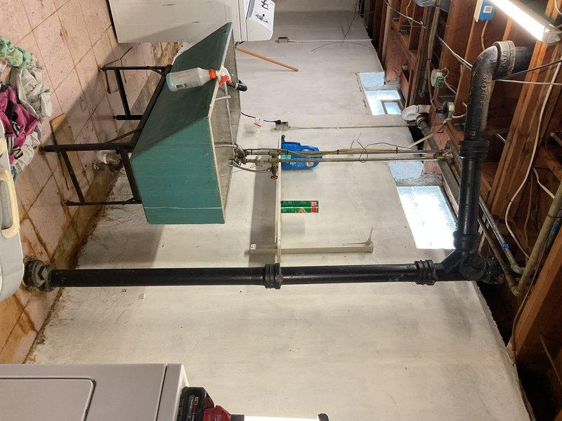 Responded to service call for clogged drain pipe in basement of 40-year-old residential property. Diagnosed severely deteriorated waste pipes connected to washtub showing significant rotting and water damage with visible mold growth along concrete wall junction. Conducted additional assessment of customer's water heater that had failed city inspection requirements per customer request.
