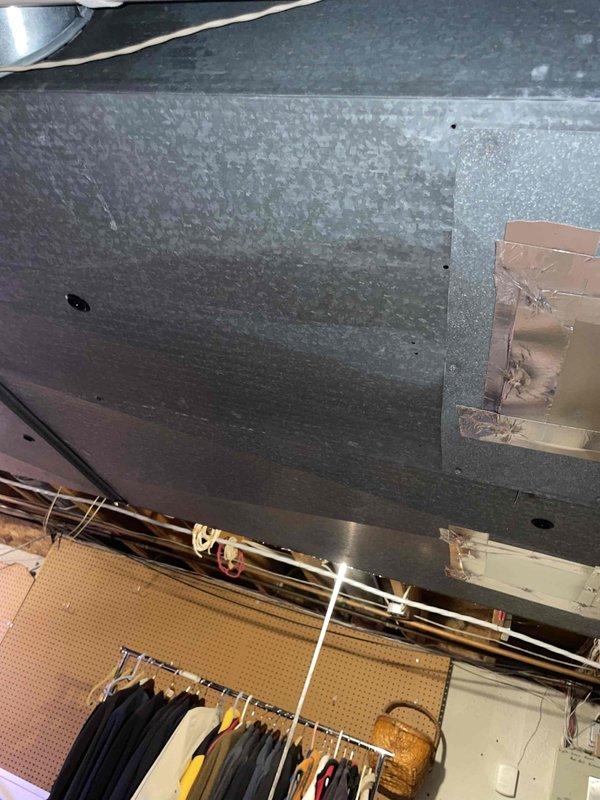 Performed assessment of 10+ year old natural gas furnace located in basement. Unit is operational but showing significant wear with visible scratches on metal cabinet, requiring replacement. Observed existing ductwork with repair patches and metal tape sealing in adjacent area, which will need to be properly connected to new furnace system when installed.