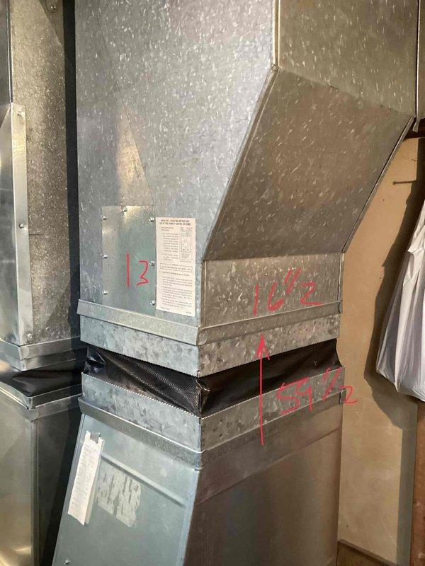 Conducted diagnostic assessment on 20-year-old leaking furnace located in basement. Inspection revealed aging galvanized ductwork with vibration isolation connections and handwritten measurements (12" and 10½") marked on the metal surfaces. Recommended full replacement due to equipment age and condition, with new PVC venting as indicated by existing utility area markings.