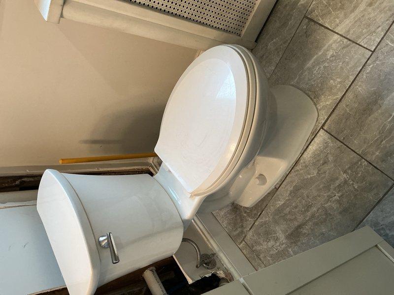 Completed stack repair and toilet servicing in customer's bathroom. Measured existing radiator (approximately 49-55 inches) to ensure proper clearance for plumbing work. Inspected and repaired drain line connections at toilet base, addressing issues where flooring meets wall to ensure proper sealing and prevent future leaks.