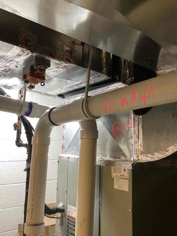 Conducted furnace replacement estimate for 12-year-old unit located in basement. Inspected existing HVAC system including ductwork connections, PVC ventilation piping, and zone control components. Documented current installation with particular attention to the sealed joints in galvanized metal ductwork and insulated components for proper assessment of replacement requirements.