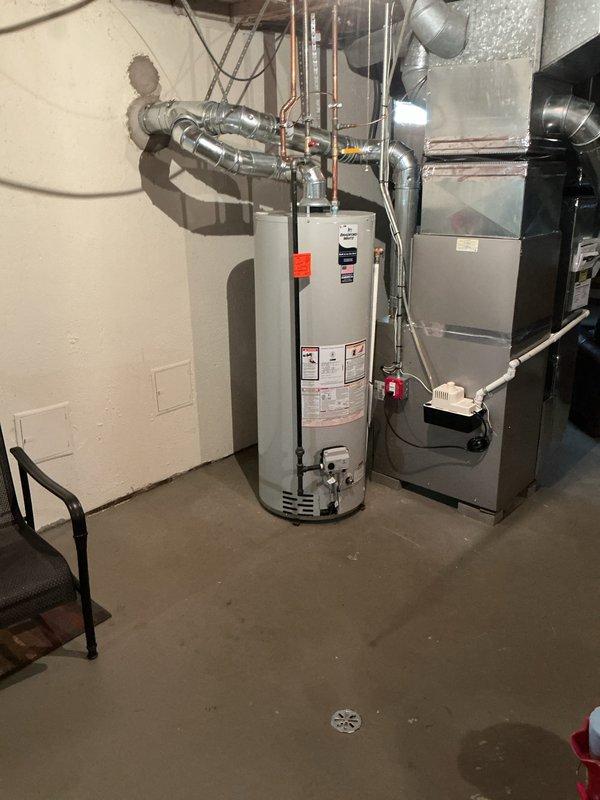 Returned to customer's residence to install a drip pan beneath the water heater in the basement utility room. Successfully installed the pan under the existing water heater unit, which is positioned adjacent to the HVAC system. Documented completed installation with photos showing proper placement of the drip pan for warranty purposes.