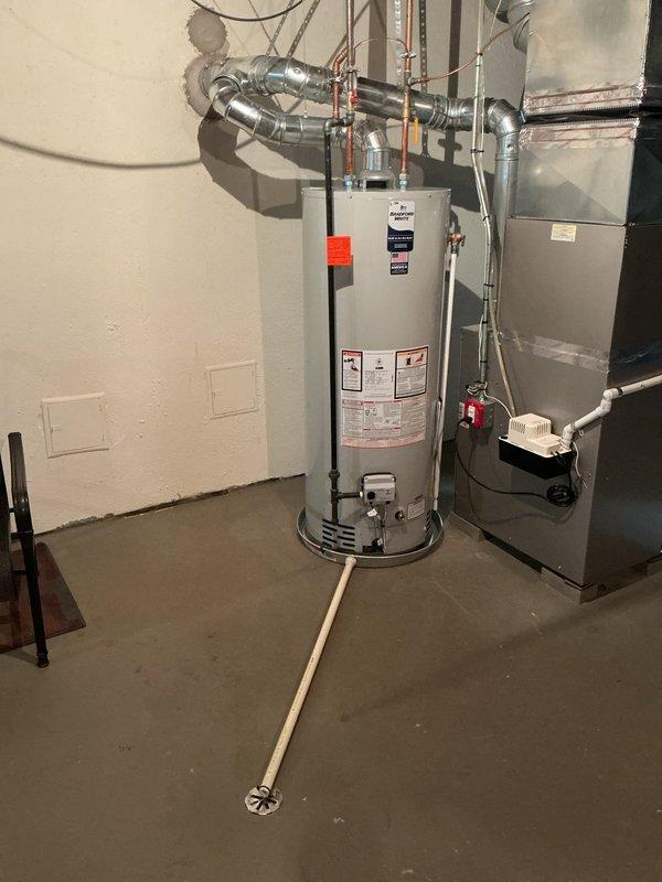 Returned to customer's residence to install a drip pan beneath the water heater in the basement utility room. Successfully installed the pan under the existing water heater unit, which is positioned adjacent to the HVAC system. Documented completed installation with photos showing proper placement of the drip pan for warranty purposes.